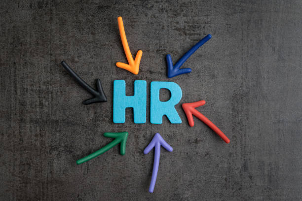 Colorful arrows pointing to the word HR at the center on black cement blackboard wall, represent Human Resource department, hiring new job or position in company stock photo