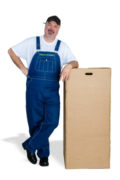 istock Smiling delivery man standing by big cardboard box 923104384