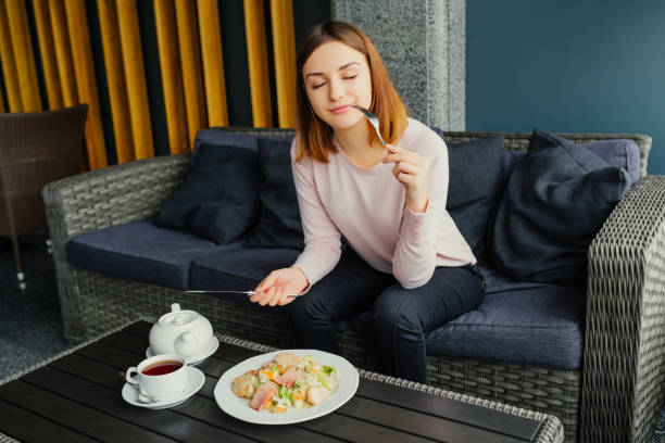 istock Beautiful girl having dinner, lunch at cafe, using cutlery and relishes salad caesar. 923110842