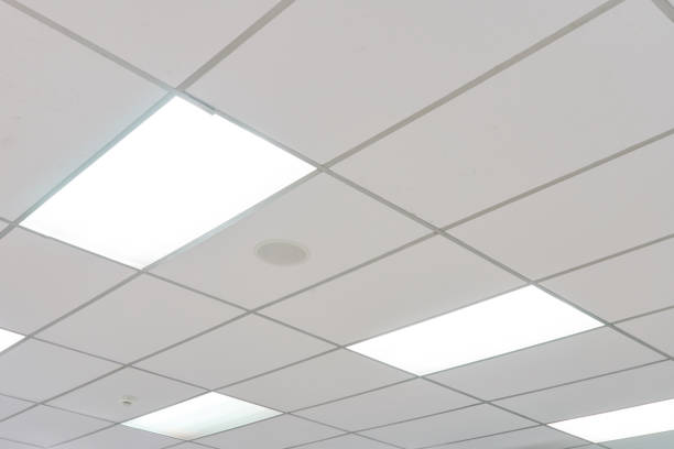 White ceiling with neon light bulbs in uprisen view.as background interior decoration concept with copy space for your text or design. White ceiling with neon light bulbs in uprisen view.as background interior decoration concept with copy space for your text or design. ceiling tile lighting stock pictures, royalty-free photos & images