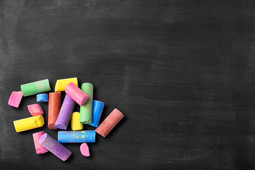 Blackboard with colorful broken chalks with copy space for add text.