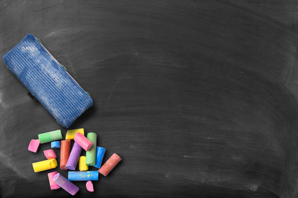 Blackboard with colorful broken chalks and board eraser Blackboard with colorful broken chalks and board eraser, with copy space for add text. board eraser stock pictures, royalty-free photos & images