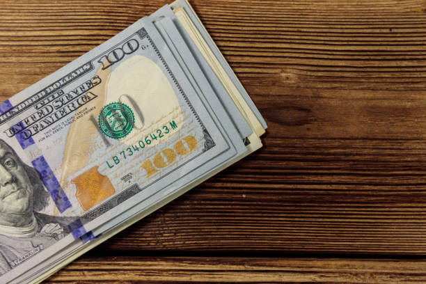 istock Stack of one hundred dollars bills on wooden desk 923117072