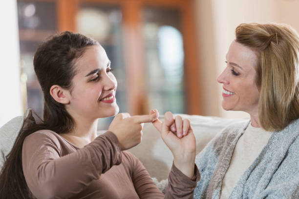 istock Teenage girl with mother, using sign language 923126546
