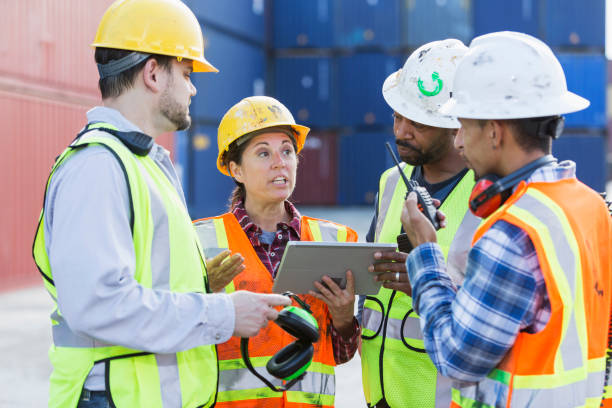 istock Multi-ethnic workers at shipping port, woman in charge 923129900