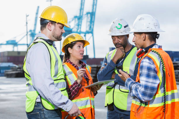 istock Multi-ethnic workers at shipping port, woman in charge 923129958