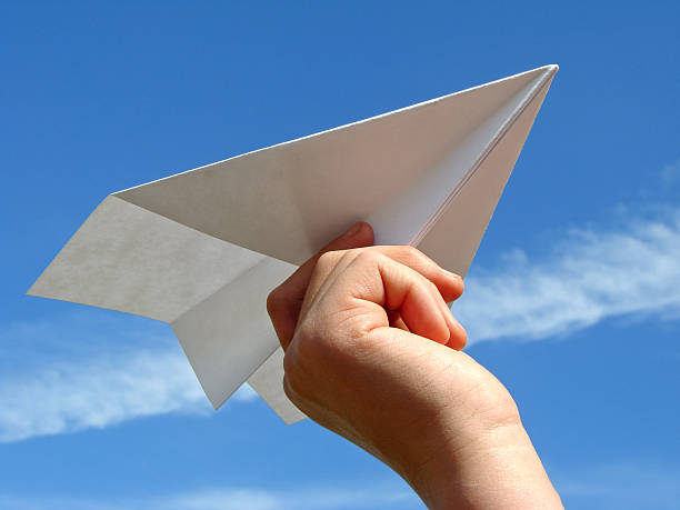 istock child hand with paper plane 92313838