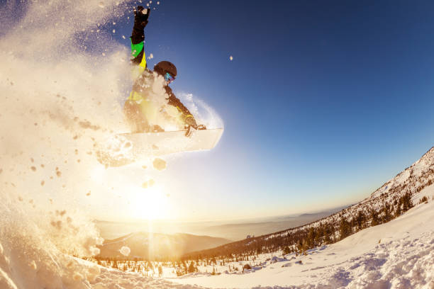 snowboarder salta contra o sol do sol - action winter extreme sports snowboarding - fotografias e filmes do acervo