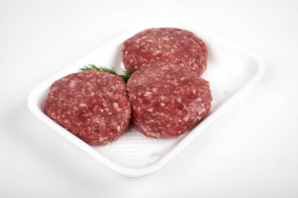 istock Tray with raw beef burgers isolated on white background 923148688