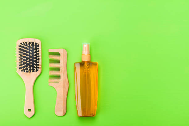 istock two combs for hair and spray on a green background 923155240