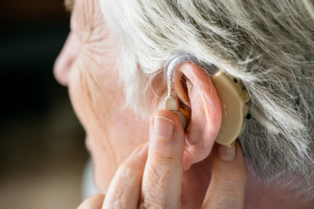 Elderly woman wearing a hearing aid Elderly woman wearing a hearing aid atrophy photos stock pictures, royalty-free photos & images