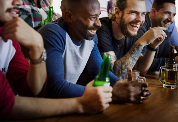 一緒にバーでスポーツを応援する友人 - drinking beer pub bar ストックフォトと画像