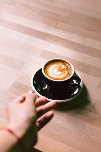 istock Woman's hand reaching coffee on a black plate 923163668