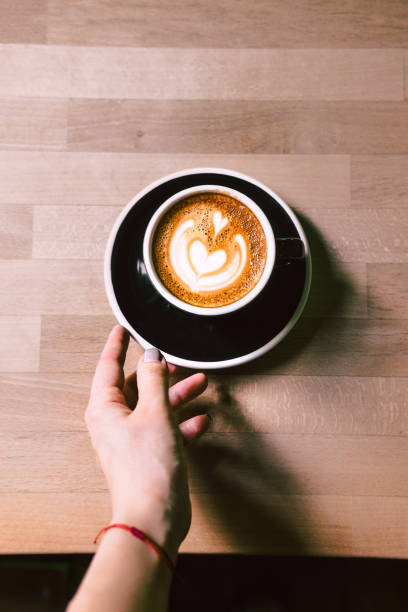 istock Woman's hand reaching coffee on a black plate 923163678