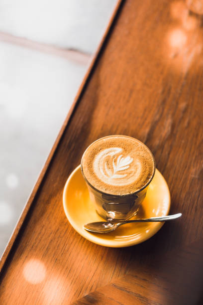 istock Latte art coffee glass on yellow plate from above 923163682