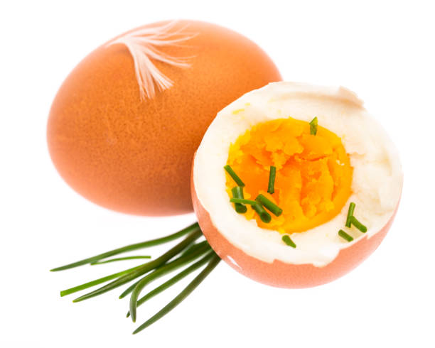 uovo intero e mezzo sodo con erba cipollina e decorazione di piume su sfondo bianco - hard cooked egg foto e immagini stock