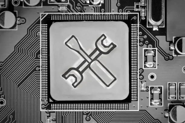 Macro photo of circuit board and chip with Tools icon imprinted on metal surface