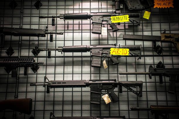 assault rifles for sale like the ar-15 and ar-10 hanging on the wall - armamento imagens e fotografias de stock