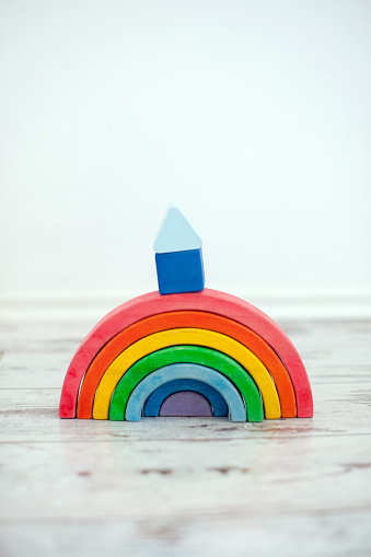 A wooden rainbow with a cubbyhole on it