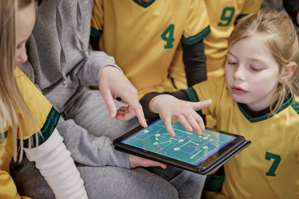 giovane bionda donna allenatore di calcio e la sua squadra di calcio ragazza - strategy coach soccer digital tablet foto e immagini stock