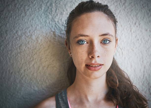 istock Beautiful blue-eyed brunette standing by textured wall daydreaming 923188896