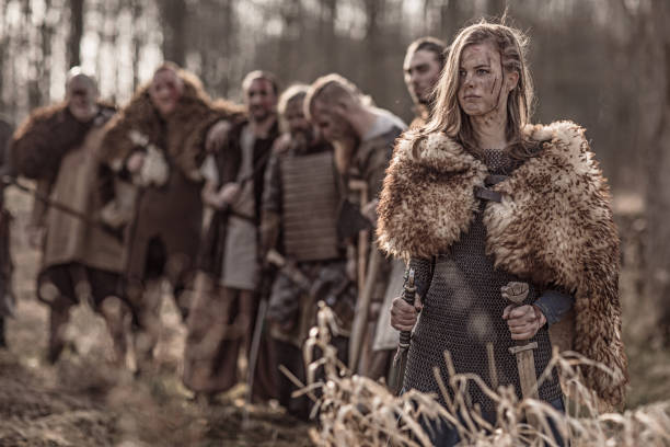 Beautiful Viking warrior royal female with her army on a winter battlefield forest Beautiful Viking warrior royal female with her army on a winter battlefield forest live action role playing photos stock pictures, royalty-free photos & images