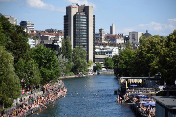The River Limmat with people takimng a sunbath and swimming on a sunny day.
