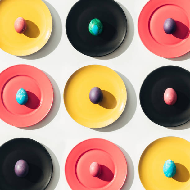 istock top view of easter eggs on yellow, red and black plates 923194414