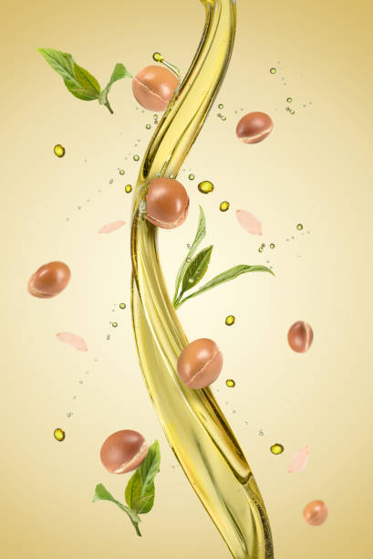 Argan fuits and leave with oil splash on green background stock photo