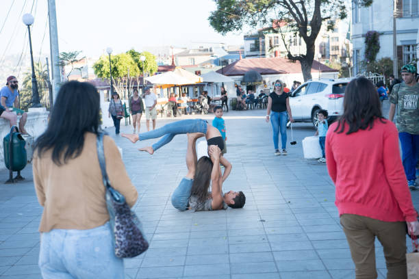 Valparaiso, Chile - January 25, 2018: Street performers. Couple doing acrobatics. Common scene from the Valparaiso viewpoints. Tourists watching. Valparaiso is twin city with Vina del Mar, west of Santiago.