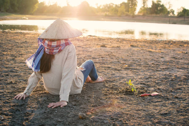istock Woman Sitting On Field By Lake 923207054