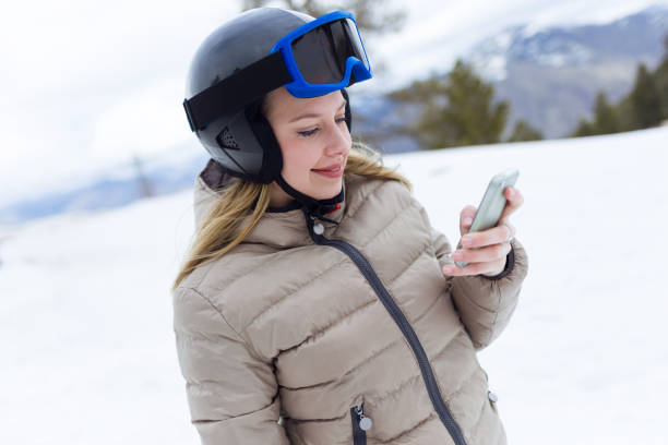 istock Beautiful young woman using her mobile phone over winter background. 923212050