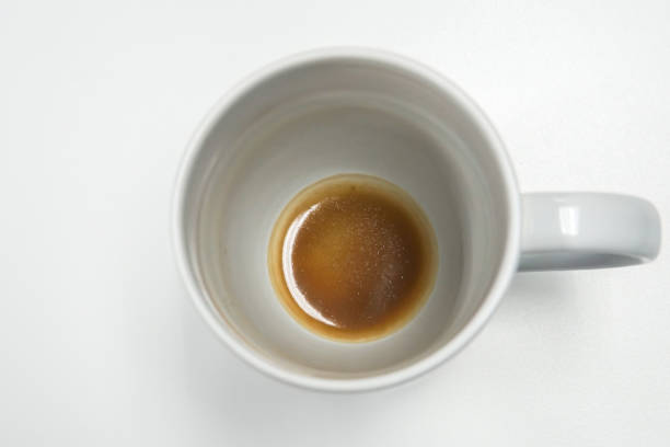 istock isolated white mug with coffee stain and residue at bottom on office desk 923212230
