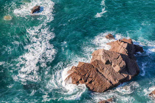 istock turquoise water and waves are broken against a stone 923215774
