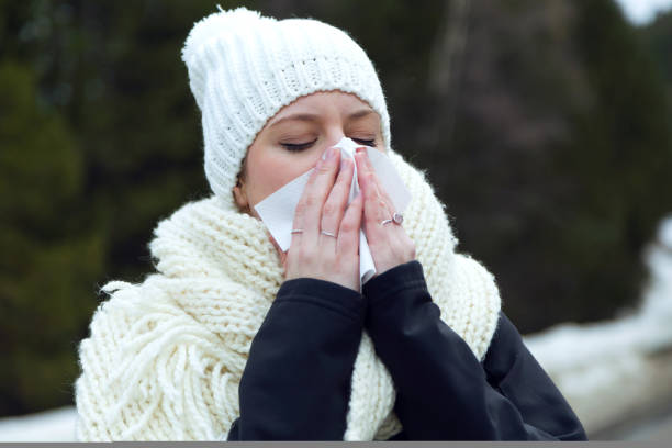 istock Beautiful young woman with tissue having flu over winter background. 923217668