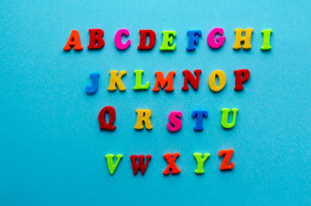 plastic magnetic colored english alphabet on blue background - blackboard teaching preschool alphabet imagens e fotografias de stock