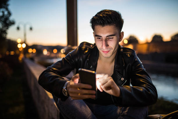 istock Stylish young man using smartphone outdoors 923218450