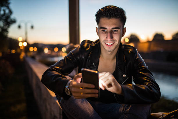 istock Stylish young man using smartphone outdoors 923218496