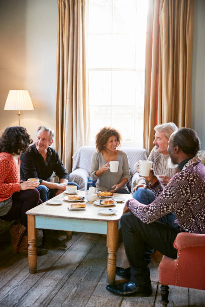 group of middle aged friends meeting around table in coffee shop - friendship cafe social gathering talking imagens e fotografias de stock