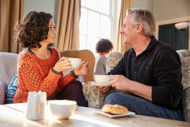 Middle Aged Couple Sitting Around Table In Coffee Shop