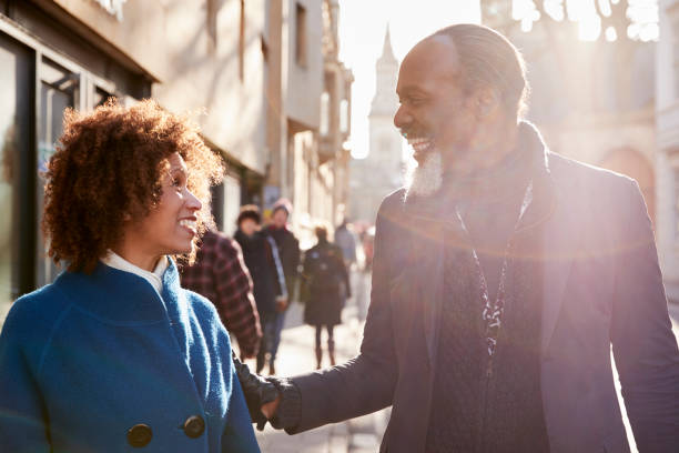 Middle Aged Couple Walking Through City In Fall Together
