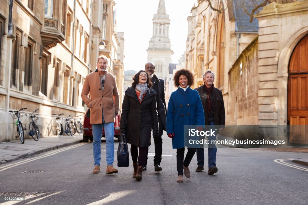 Grupo de amigos maduros, percorrendo a cidade em queda juntos - Foto de stock de Turista royalty-free