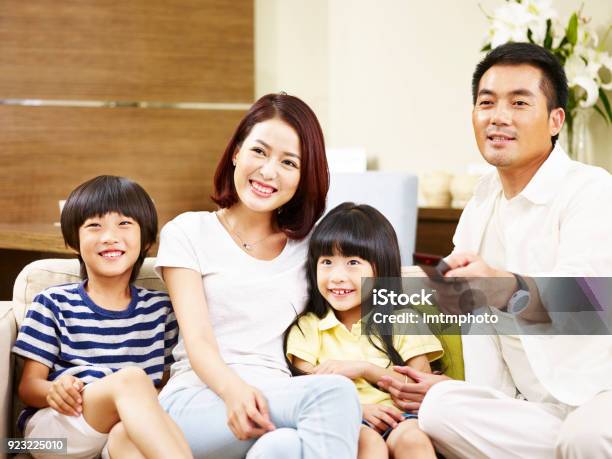 Asian Family Watching Tv Together At Home Stock Photo - Download Image Now - East Asian Ethnicity, Adult, Asia