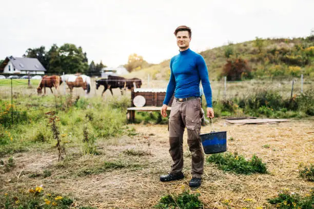 Photo of Portrait Of Young Farmer Holding Bucket