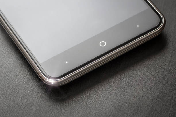 A smart phone is on the table A smart phone rests on a black office desk close-up. black glass surface stock pictures, royalty-free photos & images