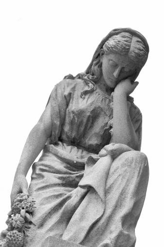 A woman on a marble statue holding flowers has a look of thinking, pondering, grieving,....White background.