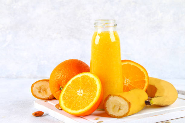 istock Orange smoothies from orange, banana on a gray concrete table. 923241114