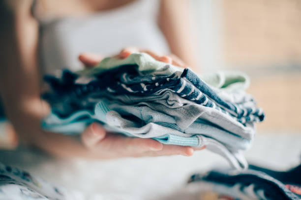 istock Mother sorting newborn baby clothing for ironing 923244182
