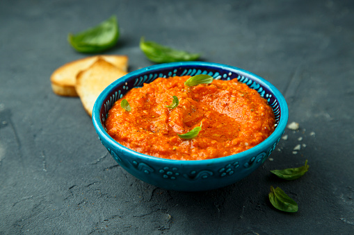 Homemade red pepper dip with fresh basil