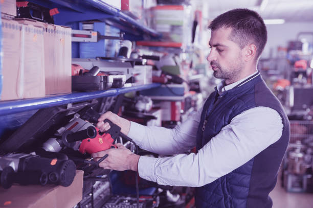 istock Adult male is standing with puncher in tools store. 923246196